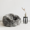 african side table in black wood and a large grey bean bag chair